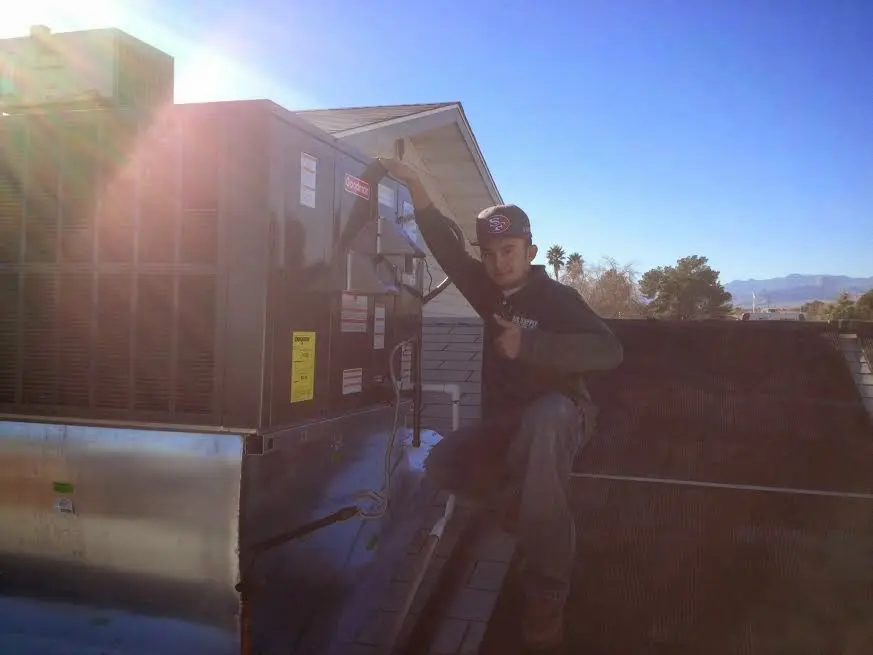 HVAC technician performing Heat Pump Repair on a rooftop unit in Jonesboro
